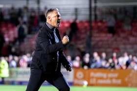 Crawley Town boss doing his trademark celebration with fans after a win. Picture: Eva Gilbert