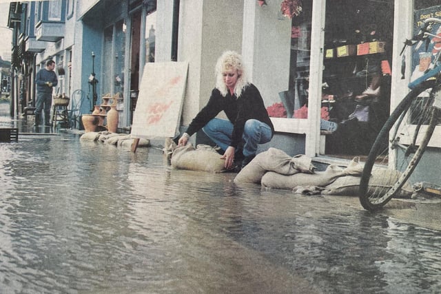 Diana Russell tries to keep water away from her shop in The Hornet.