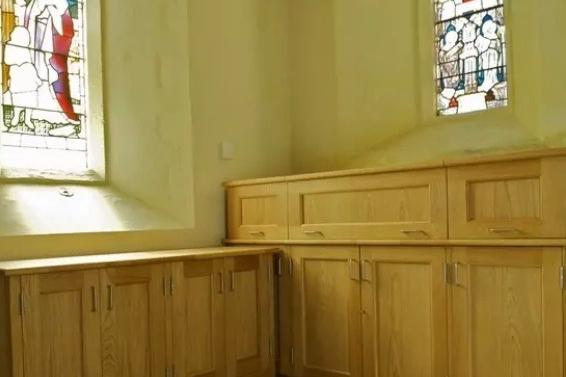 Purpose-built new oak cupboards were designed to provide practical storage that complemented the historic character of the church