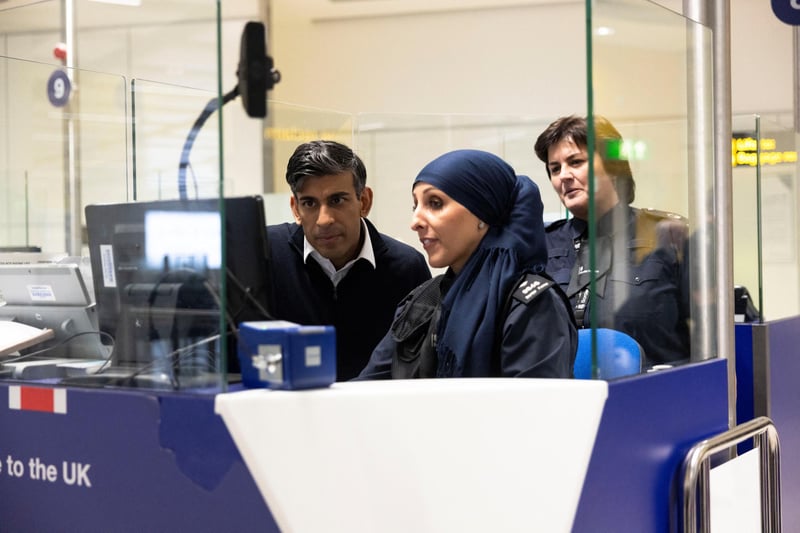 Rishi Sunak looks at the passport control unit next to Border Force officer Samira Bazzar at Gatwick Airport. (Photo by Carlos Jasso - WPA Pool/Getty Images)