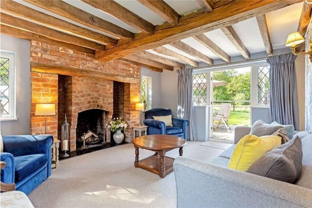 A sitting room with an open fireplace and French doors to the garden is another lovely reception area in which to relax