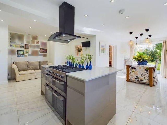 A central island hosts an inset Range cooker and space for breakfast bar seating