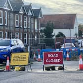 A photo shows West Street in Sompting has been fenced off in both directions, at the junction with Church Lane, with a pile of rubble and cones visible. Photo: Eddie Mitchell