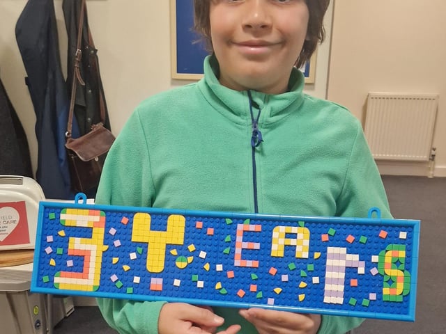 Young visitor Kai with sign made in Kid's Room