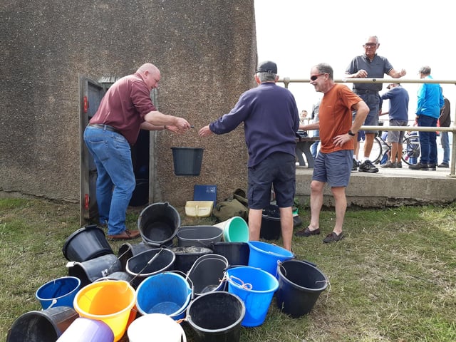 A bucket chain of volunteers from Ferring History Group and Ferring Conservation Group, including Worthing West MP Sir Peter Bottomley, form a bucket chain to bail out nine inches of water from the Ferring pillbox