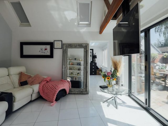 The comfortable lounge, with its large doors leading outside, is being used as a cinema room.