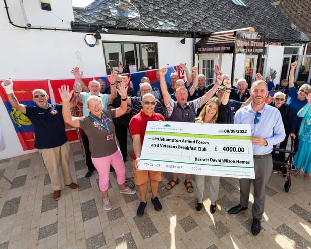 Kimberley Benson, southern counties sales and marketing director, presents Littlehampton Armed Forces and Veterans Breakfast Club with the £4,000 cheque from David Wilson Homes