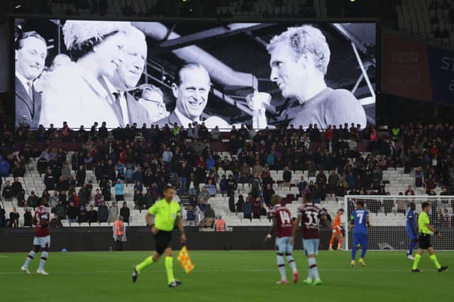 The LED board shows the images of Queen Elizabeth II awarding the Jules Rimet World Cup Trophy to Bobby Moore after England won the 1966 World Cup final at Wembley, after it was announced that Queen Elizabeth II has passed away today during the UEFA Europa Conference League group B match between West Ham United and FCSB at London Stadium on September 08, 2022 in London, England. (Photo by Richard Heathcote/Getty Images)