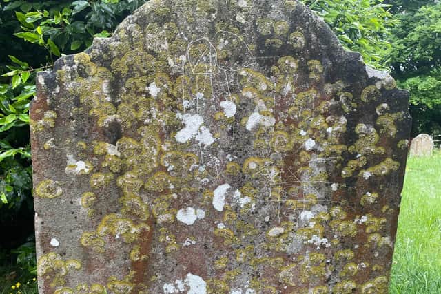 The defaced gravestone at St Peter's Church, Cowfold