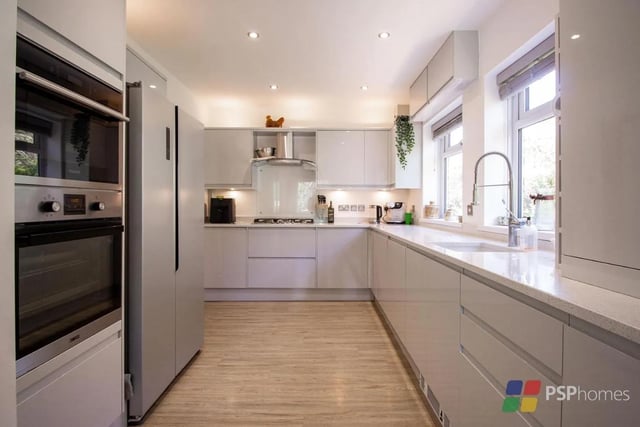 The kitchen has modern grey gloss units, quartz worktops and integrated appliances