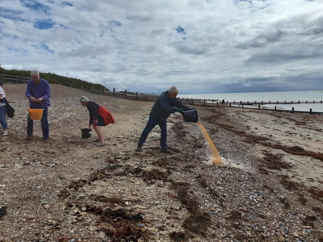 A bucket chain of volunteers from Ferring History Group and Ferring Conservation Group, including Worthing West MP Sir Peter Bottomley, form a bucket chain to bail out nine inches of water from the Ferring pillbox