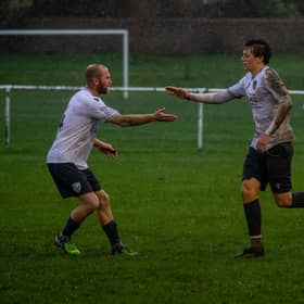 Players congratulating Bexhill Utd goal hero Theo Coombs | Picture by Amy Marshall