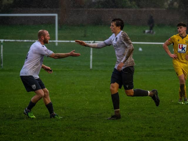 Players congratulating Bexhill Utd goal hero Theo Coombs | Picture by Amy Marshall