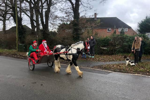 Teenage 'elf' Sidney Brazil with 'Santa' Steve Darby on their Christmas rounds with pony Tiny Tim in Barns Green