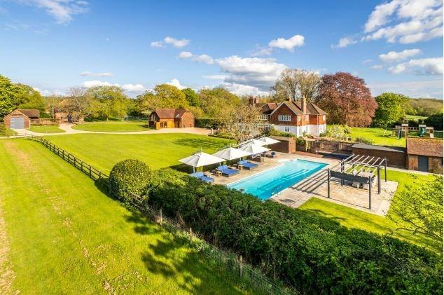 A bird's eye view of the property with its pool, grounds, cottage and coach house