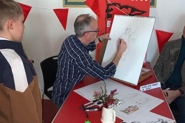 Illustrator Mark Bergin demonstrating his sketching for history lover Alex who attended the book launch 