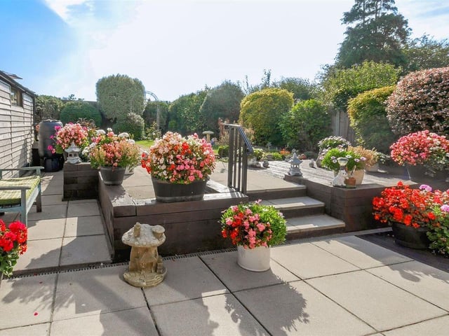 The beautiful south-facing garden has a patio, raised timber decking and lawn