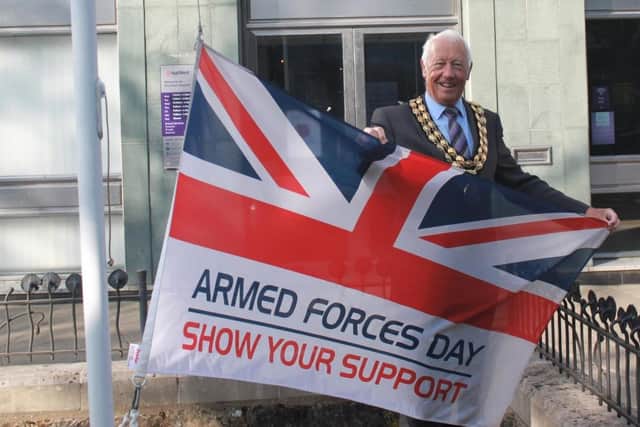 Horsham District Council chairman David Skipp raises the flag to begin Armed Forces celebrations