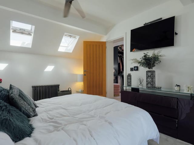Here is the master bedroom on the first floor, complete with skylights and ceiling fan. It leads into a dressing room which, in turn, leads to the main bathroom.