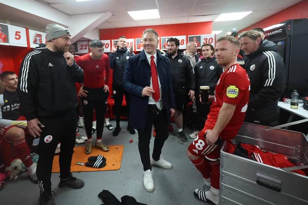 Crawley Town manager Scott Lindsey celebrates with his staff and players in the dressing room after the match | Telephoto Images
