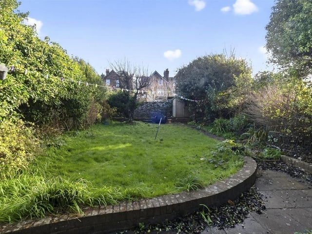 The back garden enjoys a sheltered sun-trap aspect with established planting