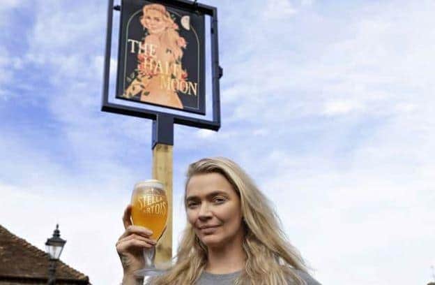 Supermodel-turned-pub-landlady Jodie Kidd with the racy sign outside her pub, the Half Moon at Kirdford