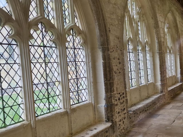 The large perpendicular traceried windows are the same throughout the Cloisters, with benches on their insides