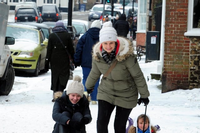 A mum pulling her children along the snowy streets of Midhurst