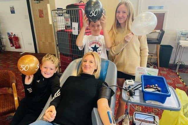 Abi Smith, giving her 50th blood donation, watched by proud children Lily, 12, Henry, nine, and seven-year-old Tommy