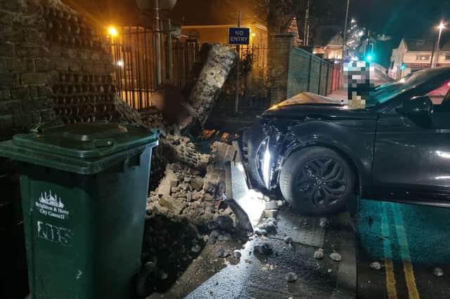 Police were spotted next to a damaged car and collapsed wall in Brighton on Saturday, February 18