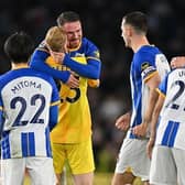 Brighton's Argentinian midfielder Alexis Mac Allister (C) celebrates with teammates on the pitch after his late winner against Manchester United