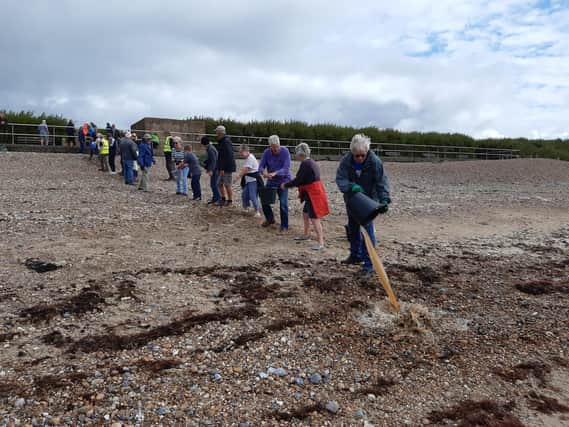 A bucket chain of volunteers from Ferring History Group and Ferring Conservation Group, including Worthing West MP Sir Peter Bottomley, form a bucket chain to bail out nine inches of water from the Ferring pillbox