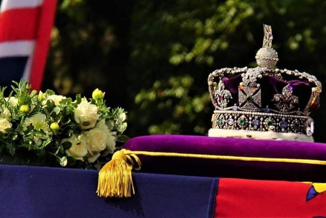 On top of the coffin is the Imperial State Crown encrusted with almost 3,000 diamonds and a bouquet of flowers and plants, including pine from the Balmoral Estate. Photo: Julie Boylett