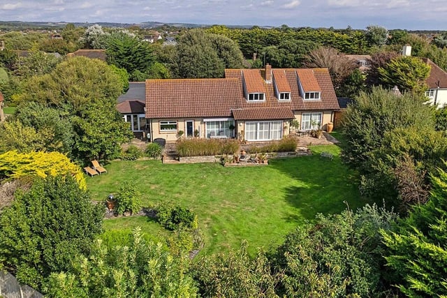This spacious, four-bed detached house is situated in the sought-after Kingston Gorse private estate. It has four reception rooms, a modern kitchen/family room and a pool room/gym with swim spa. It has a guide price of £1.6million.