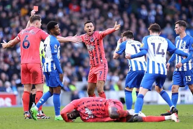 Referee, Tony Harrington gives a red card to Billy Gilmour of Brighton for a foul on Amadou Onana of Everton