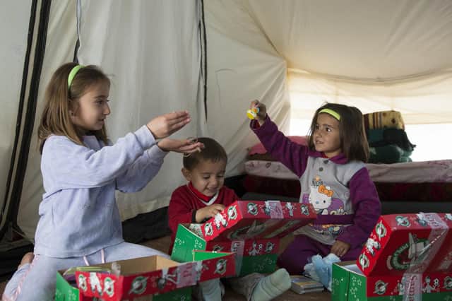 Refugees opening an Operation Christmas Child shoebox. Picture: Jon Black