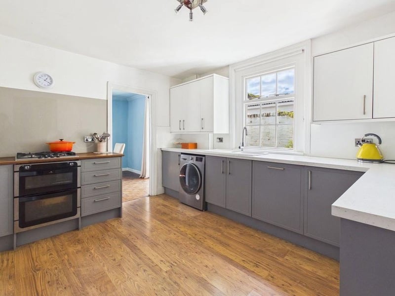 The kitchen is fitted with a range of stylish two-tone units