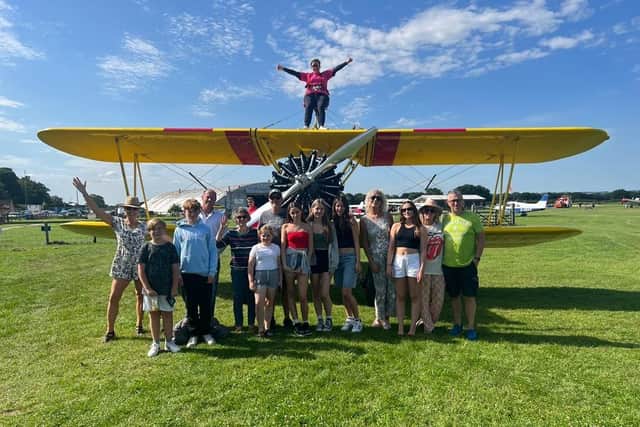 Catherine Clifford strapped to a 1940s bi-plane surrounded by family andd friends
