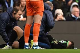Brighton's Solly March covers his face before being stretchered off injured at Man City last October