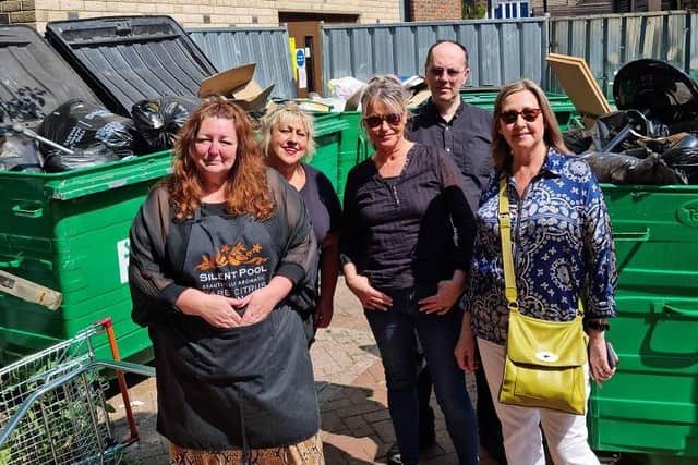 Shopkeepers with some of the bins currently housed in Park Place, Horsham. The district council wants to build a roofless £100,000 brick-walled store to house the bins.