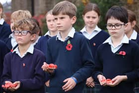 Highfield and Brookham pupils hold their ceramic poppies during the Act of Remembrance