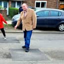 Alison Cornell and Michael Jones with the repaired potholes in Langley Drive. Pictures contributed