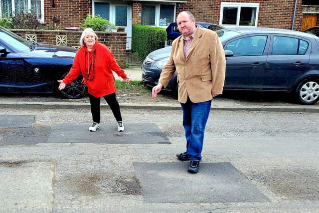 Alison Cornell and Michael Jones with the repaired potholes in Langley Drive. Pictures contributed