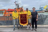 Zeyang Li presented a traditional flag to the crew at Newhaven Lifeboat Station to thank them for saving his life in May 2026. Photo: Newhaven RNLI