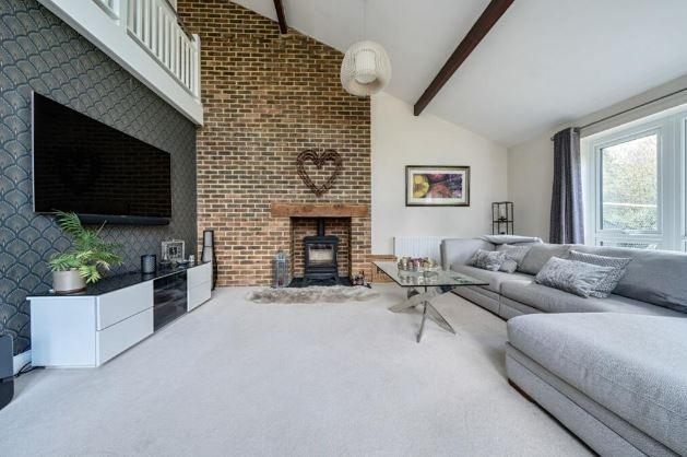 A separate sitting room centres around the fireplace with an inset log burner. It has a high vaulted ceiling giving a feeling of light and space andthe double aspect provides views over the rear gardens with double doors opening directly onto the rear garden terrace.