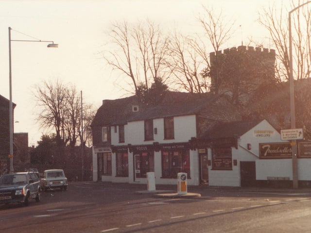 The area around the cross, with the St Mary's Church tower visible behind the shops
