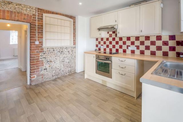 The kitchen has stunning exposed brick walls and hardwood floors.