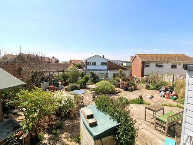 In the garden the decked area leads to an artificial lawn and steps down to swimming pool. The steps lead up to a patio area with mature planting, with decking next to a timber studio, a rockery with a pond and a bank with wildflower planting.