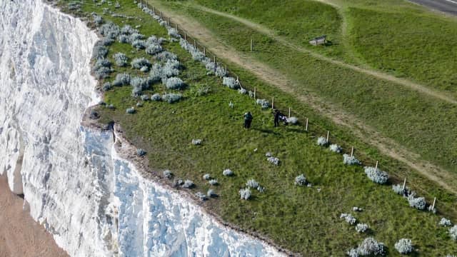 People climbing over the barrier near the cliff edge in Saltdean on Thursday, May 7. Photo: Eddie Mitchell