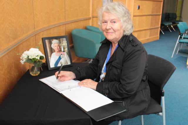 Horsham District Council chairman Kate Rowbottom signs the book of condolence for Queen Elizabeth II at the council offices in Parkside